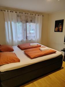 a bedroom with a large bed with orange sheets at Marikollen, spacious appartment with sunny veranda in Kristiansand