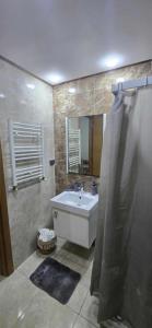 ein Badezimmer mit Waschbecken und Spiegel in der Unterkunft Oumaima in Sidi Daoud