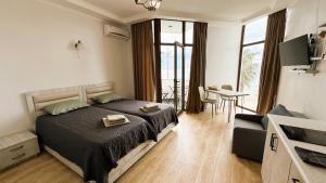 高尼奥SofiCoast的一间带床的卧室和一间带桌子的客厅