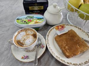 a plate with a cup of coffee and a piece of toast at Room Lidón Center 1 in Castellón de la Plana +13 photos