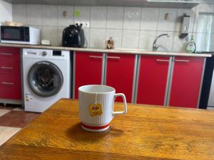 a coffee cup sitting on a table in a kitchen at Apartament Otopeni#Aeroport#Therme#Natatie in Otopeni