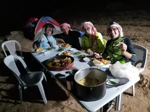 a group of people sitting around a table with food at Tafila-Mataan in Al Jafr +41 photos