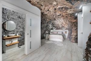 una camera da letto in una grotta con un letto e un bagno di Luxury Home la Cueva del Guanche ad Adeje Altre 29 foto