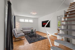 a living room with a couch and a tv at Maisonette apartment in Basel with free parking! in Allschwil