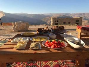 a wooden table with plates of food on it at Tafila-Mataan in Al Jafr