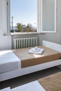 a bed with a towel on it in a room with a window at Trilocale Longarone 3 Rimini in Rimini