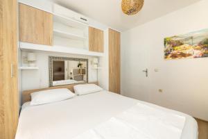 a bedroom with a white bed and a window at tiho's apartments in Split