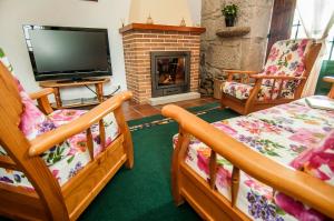 a living room with two beds and a fireplace at Casa Rural Rectoral de Areas Tui in Tui