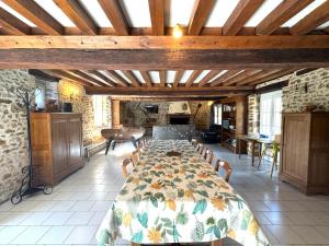 a large dining room with a table and a kitchen at La Maison des Pommiers, 12p, idéale familles et amis in Orgères