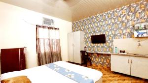 ein Schlafzimmer mit einem Bett und einem Fernseher an der Wand in der Unterkunft HOTEL SYL II -Couples, Corporates, Family, Faculties Favourite in Phagwara