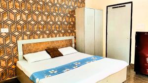 Bett in einem Zimmer mit einer Wand in der Unterkunft HOTEL SYL II -Couples, Corporates, Family, Faculties Favourite in Phagwara
