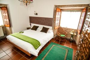 a bedroom with a large bed and a green rug at Hotel Rectoral de Areas Tui in Tui