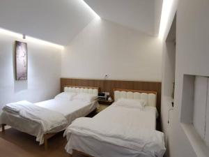 Postel nebo postele na pokoji v ubytování 威海荣成拾栖海舍 + 4 fotografie