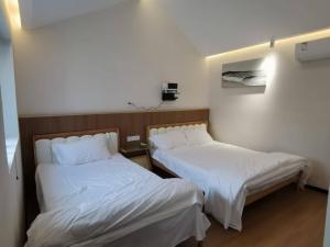 Postel nebo postele na pokoji v ubytování 威海荣成拾栖海舍