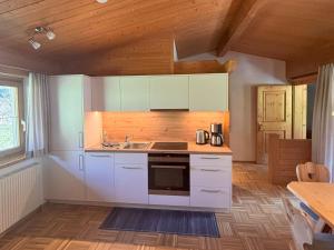 een keuken met witte apparatuur en een houten plafond bij Apartment Sonnegg by Interhome in Vandans