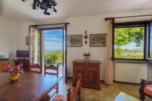 una sala da pranzo con un tavolo e una grande finestra di Villa Campo al Pero a Rio Marina