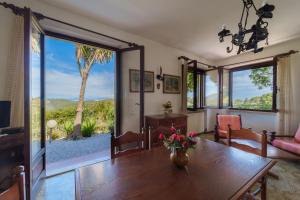 un soggiorno con tavolo e una grande porta scorrevole in vetro di Villa Campo al Pero a Rio Marina