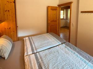 een slaapkamer met een bed met een deken erop bij Apartment Sonnegg by Interhome in Vandans +16 foto's