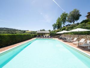 a swimming pool with chairs and umbrellas at Apartment Raffaello by Interhome in Montaione