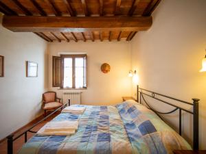 a bedroom with a bed and a window and a chair at Apartment Giotto by Interhome in Montaione