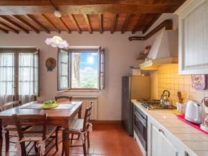a kitchen with a wooden table and a kitchen with a window at Apartment Giotto by Interhome in Montaione