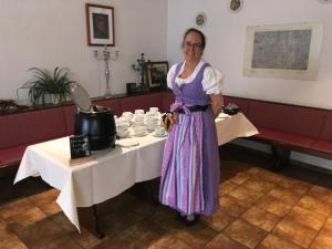 una mujer parada frente a una mesa con tazas en Onkel Tom`s Hütte, en Gotinga