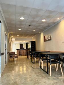 une pièce avec des tables et des chaises et une cuisine dans l'établissement Nuevo Hotel Córdoba, à Villa Carlos Paz