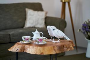 two birds sitting on a coffee table with tea cups at Sparrow Sintra Nest in Sintra