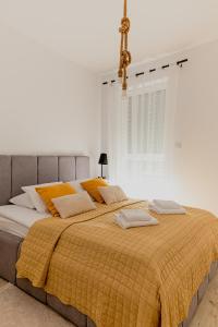 a bedroom with a large bed with yellow blankets and pillows at Resort Apartamenty Klifowa Rewal 97 in Rewal +21 photos
