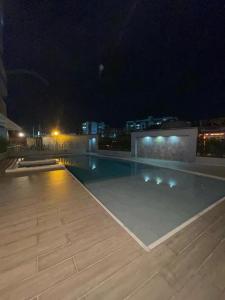 多斯克布拉达斯Apartamento cerca a Pereira的夜晚的建筑物顶部的游泳池