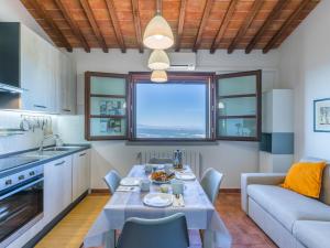 a kitchen and living room with a table and a couch at Apartment Sughera by Interhome in Podere Dottrina