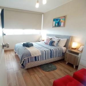利马EuVe Ocean View Flat in Lima的卧室里有一张床，床上铺着蓝白相间的毯子 更多21张照片
