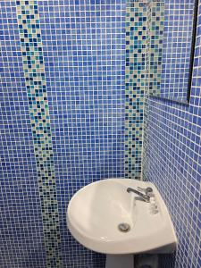 a blue tiled bathroom with a sink and a mirror at GN House Bangtao in Ban Thalat Choeng Thale +18 photos