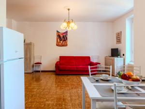 a living room with a red couch and a table at Apartment Condominio dei Giardini by Interhome in Bellano