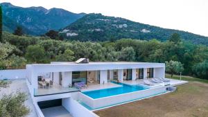 a house with a swimming pool and mountains in the background at The Oasis, luxury Villa in Nidri in Palaiokatoúna