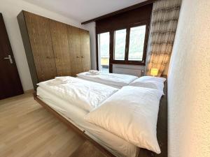 a bedroom with two beds with white pillows at Royal 51 in Leukerbad