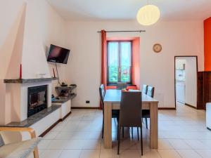 a dining room with a table and a fireplace at Holiday Home Angela by Interhome in Perledo
