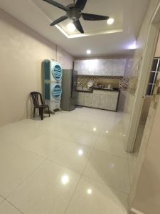 a living room with a ceiling fan and a kitchen at MM HomeStay 82 in Kamunting +10 photos
