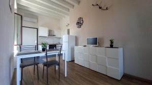 a kitchen with a table and chairs and a refrigerator at Cavour 35 in Sulbiate