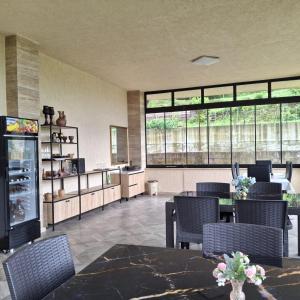 a dining room with a table and chairs and windows at KEMO house in Batumi