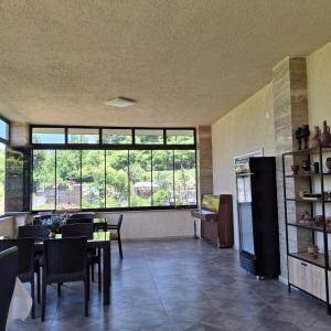 a dining room with a table and some windows at KEMO house in Batumi