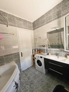 une salle de bain avec un lavabo et une machine à laver dans l'établissement Corfu Holidays Villa Kanoni, à Kanoni