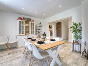 a dining room with a wooden table and white chairs at Holiday Home Cosy Home D&D by Interhome in Brod Moravice
