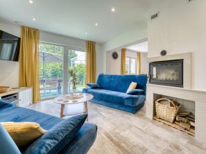 a living room with a blue couch and a fireplace at Holiday Home Cosy Home D&D by Interhome in Brod Moravice