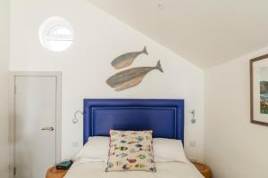 a bedroom with a bed with a blue headboard and a pillow at Beach Hut Suites in Bognor Regis +43 photos