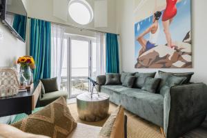 a living room with a couch and a large window at Beach Hut Suites in Bognor Regis