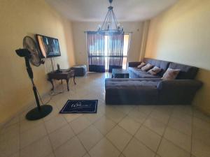 ein Wohnzimmer mit einem Sofa und einem Ventilator in der Unterkunft Chalet Marina Flowers Resort in El-Alamein