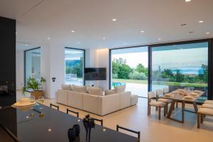 a living room with a couch and a table and chairs at The Oasis, luxury Villa in Nidri in Palaiokatoúna