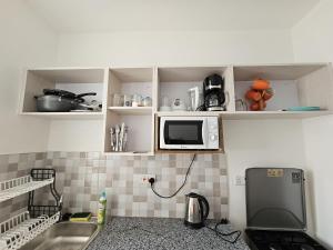 a kitchen with a sink and a microwave at SuCasa Homes in Mombasa