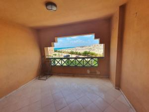 ein leeres Zimmer mit einem Balkon mit Aussicht in der Unterkunft Chalet Marina Flowers Resort in El-Alamein